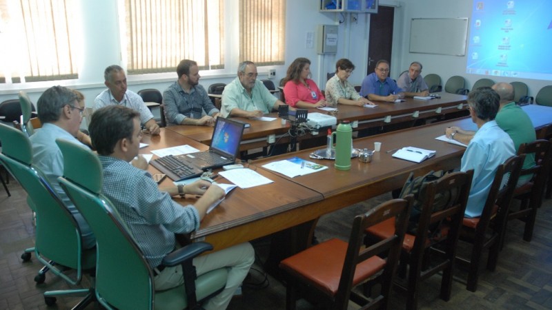 várias pessoas sentadas ao redor de uma mesa debatendo sobre a cebola