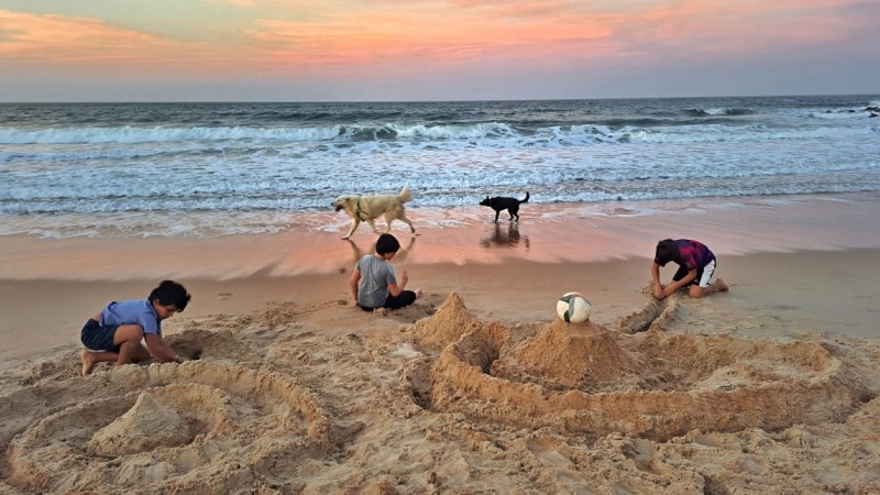 imagem de praia e crianças brincando na areia