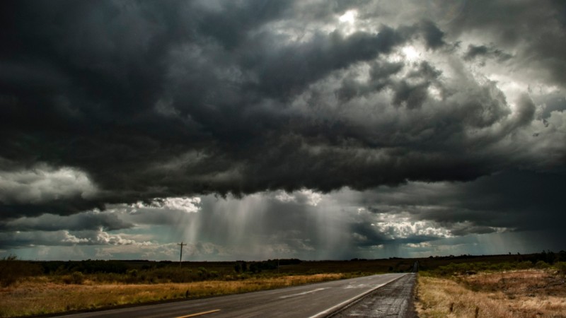 Céu carregado de nuvens escuras e chuva em uma estrada